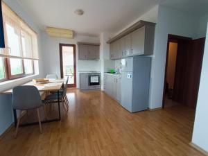 a kitchen with a table and a blue refrigerator at Bulgapart Obzor in Obzor