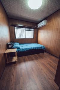 a bedroom with a bed and a table in it at 唐風家 北田辺 近邻地铁 4階 in Osaka +11 photos