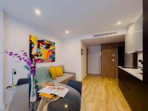 a living room with a table with a vase of flowers at Apartamento TriBeCa Centro III in Albacete