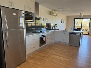 a kitchen with stainless steel appliances and wooden floors at Cowell Townhouse apartments in Cowell