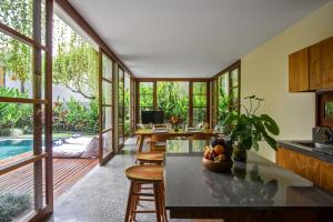 a kitchen and dining room with a table and chairs at Anandathu Villas in Mengwi