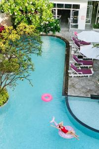 a woman laying in a pool with a frisbee at The Sea Cret Hua Hin in Hua Hin