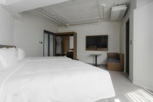 a bedroom with a large white bed and a flat screen tv at Homes Stay G-Valley Gasan in Seoul +37 photos