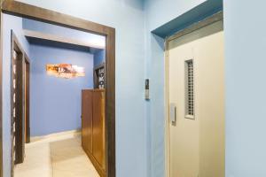 an open door leading to a hallway with blue walls at FabHotel Dream Palace in Patna
