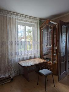 a room with a wooden table and a window at Частный дом in Bălţi