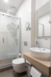 W łazience znajduje się umywalka, toaleta i prysznic. w obiekcie City Hotels Rūdninkai w Wilnie
