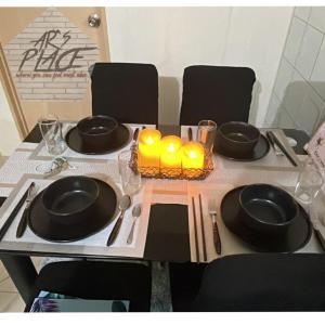 una mesa con platos negros y velas en una mesa en DECA HOMES ORTIGAS by AR's PLACE, en Manila
