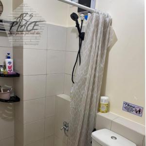 y baño con cortina de ducha y aseo. en DECA HOMES ORTIGAS by AR's PLACE, en Manila