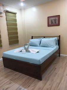 a bedroom with a bed with blue sheets and blue pillows at Marietta's Hotel in Bajuyan
