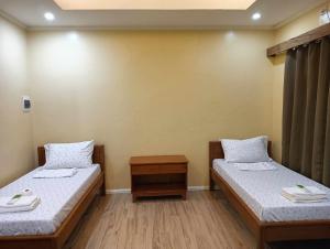 a room with two beds and a wooden floor at Marietta's Hotel in Bajuyan