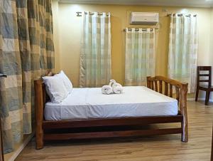 a bed with two stuffed animals sitting on it at Marietta's Hotel in Bajuyan