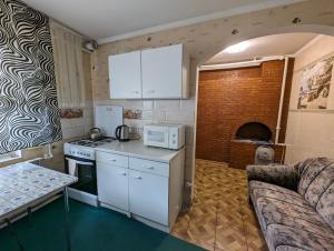 a kitchen with white appliances and a couch in a room at Частный дом in Bălţi