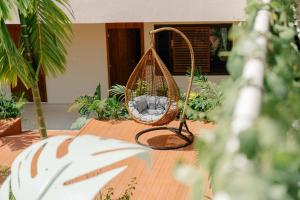 a swing sitting on a patio with plants at Samawa Living in Paje