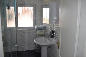 biała łazienka z umywalką i oknem w obiekcie Apartments Grgic w mieście Novigrad +13 zdjęć
