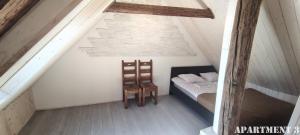 una camera da letto con un letto e una sedia in mansarda di 36 Posti a Haapsalu