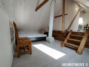um quarto no sótão com uma cama e uma cadeira em 36 Posti em Haapsalu