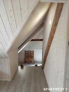 um quarto com uma cadeira de madeira num sótão em 36 Posti em Haapsalu