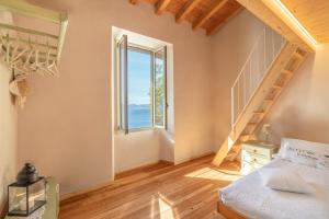 1 dormitorio con cama y ventana grande en Piccola Meraviglia Sul Garda, en Muslone