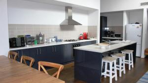 a kitchen with blue cabinets and a table with chairs at Pet Friendly With Privacy, Excellence & Wifi in Hawks Nest +8 photos