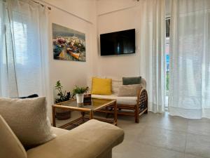 a living room with a couch and a tv at Kallithea Central Apartment in Kallithea Halkidikis