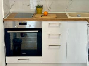 a kitchen with an oven and an orange on the counter at Kallithea Central Apartment in Kallithea Halkidikis