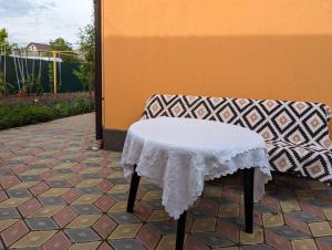 a table with a white table cloth sitting next to a couch at Частный дом in Bălţi