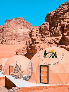 eine Gruppe von Zelten in der Wüste in der Nähe eines Berges in der Unterkunft Rum city Star LUXURY Camp in Wadi Rum