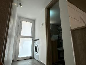 lavadero con lavadora y ventana en Topikos Apartments, en Ayia Napa