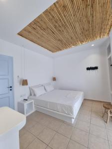 1 dormitorio con 1 cama con techo de madera en Ilias Place, en Ios Chora