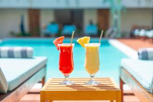two drinks sitting on a table next to a pool at Samawa Living in Paje