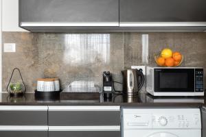 a kitchen with a microwave and some oranges on a counter at צופית דירות אירוח 2 דירות, האחת חדר שינה וסלון והשניה 2 חדרי שינה וסלון in Eilat