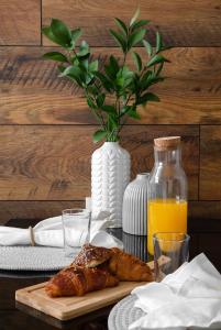 a table with a plate of croissants and a vase with orange juice at צופית דירות אירוח 2 דירות, האחת חדר שינה וסלון והשניה 2 חדרי שינה וסלון in Eilat