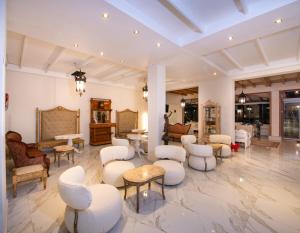 uma sala de espera com cadeiras e mesas brancas em Orpheas Resort Hotel (Adults Only) em Georgioupolis