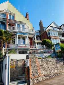 a house with a stone retaining wall and a building at Coastal Waters (Hotel Barton) in Torquay