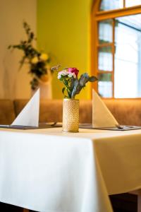 a table with a vase with flowers on it at Ferienwohnungen am Geiseltalsee in Braunsbedra