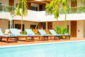 a group of lounge chairs by a swimming pool at Samawa Living in Paje