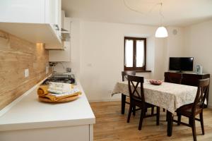 a kitchen and dining room with a table and chairs at Cjase da Maestre in Raveo