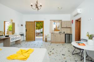 a white kitchen with a table and a yellow towel on a bed at KRANA APARTMENTS in Líndos