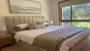 a bedroom with a large bed and a window at Hawks Nest's Holiday Gem in Hawks Nest