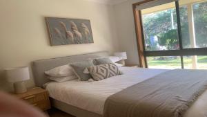 a bedroom with a large bed with a window at Hawks Nest's Holiday Gem in Hawks Nest