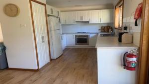 a kitchen with white cabinets and a counter top at Hawks Nest's Holiday Gem in Hawks Nest +8 photos