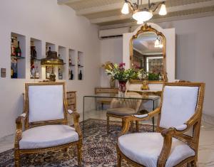 Pokój z 2 krzesłami, stołem i lustrem w obiekcie Orpheas Resort Hotel (Adults Only) w mieście Georgioupolis
