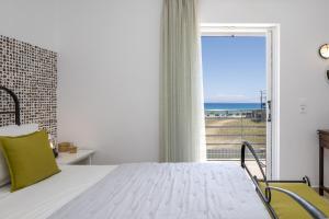a bedroom with a bed and a view of the ocean at Beachfront Villa Alexandra in Skala Kefalonias