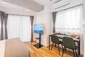 una camera con letto e scrivania con sedie di Zaito Tokyo East Mukojima APT a Tokyo