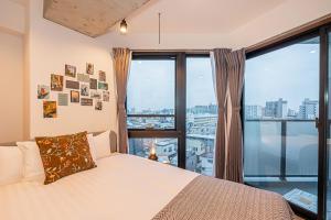 una camera da letto con un letto e una grande finestra di Zaito Tokyo East Mukojima APT a Tokyo
