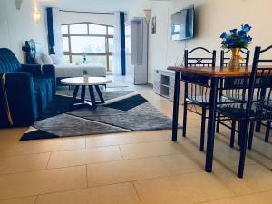 a living room with a table and a dining room at Seabreeze suites Villa in Diani Beach