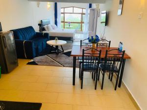 a living room with a table and chairs and a couch at Seabreeze suites Villa in Diani Beach