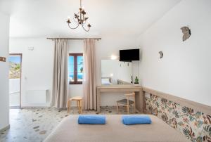 een slaapkamer met een bed en een bureau in een kamer bij KRANA APARTMENTS in Lindos