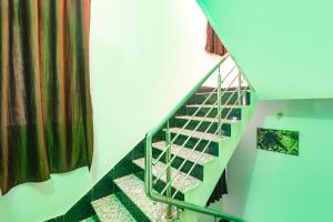 Khagaul的住宿－FabExpress Magadh Glory，房屋内带绿色栏杆的楼梯