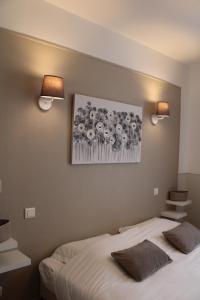 sypialnia z łóżkiem i 2 lampkami na ścianie w obiekcie Coliwork Le Saint Romain w mieście Dangé